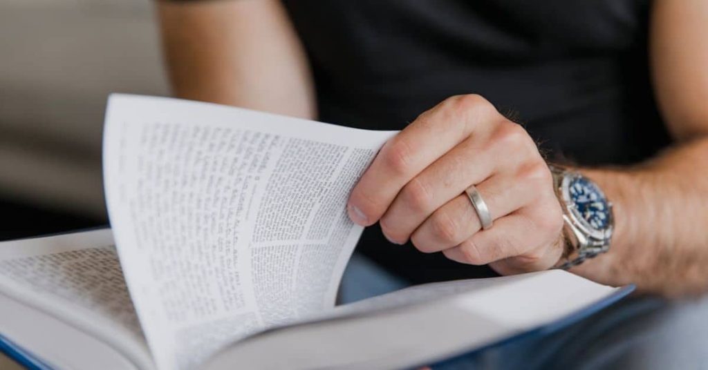 Person reading a guide book: Homesteading in Indiana